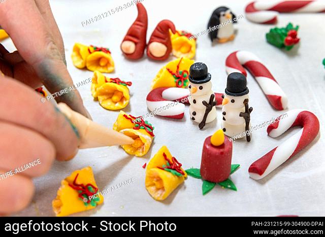 PRODUCTION - 13 December 2023, Thuringia, Erfurt: A pastry chef creates Christmas decorations for the baked specialties at the Lobenstein bakery and pastry shop
