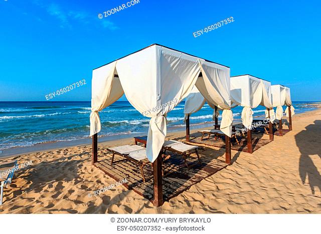 Luxury beach tents canopies on morning paradise white sandy beach The Maldives of Salento (Pescoluse, Salento, Puglia, south Italy)