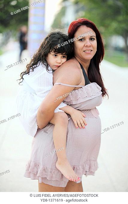 Pregnant woman holding her child in Miami Beach, Florida, USA