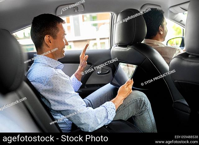 man with tablet pc having video call in taxi car