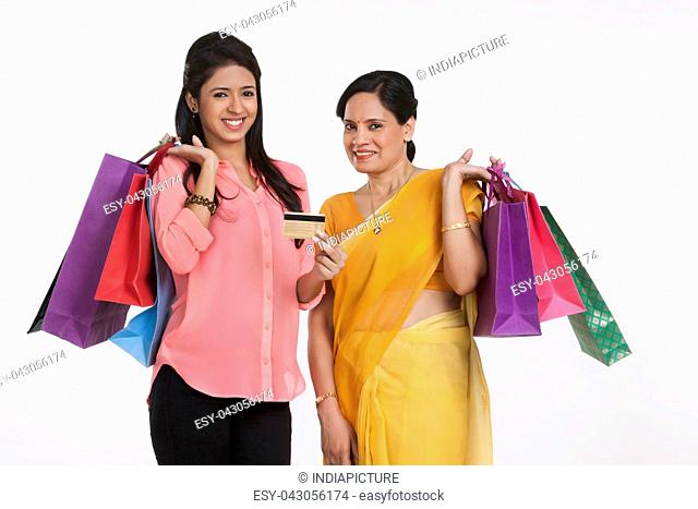 Portrait of mother and daughter with shopping bags and credit card