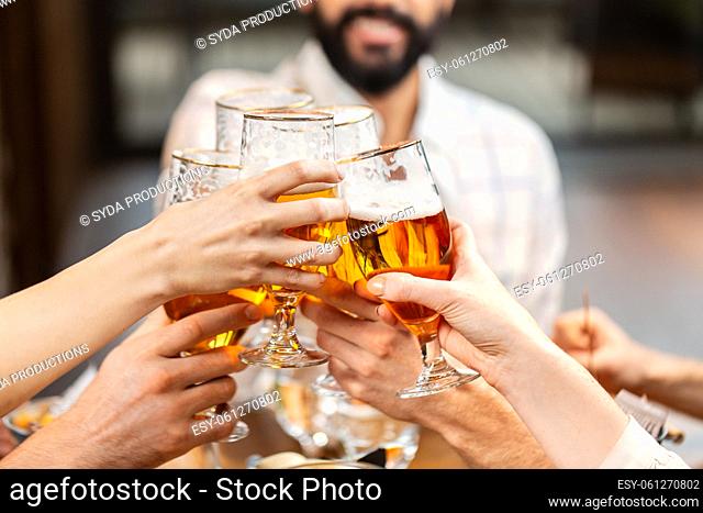 happy friends drinking beer at restaurant