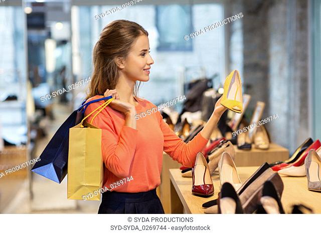happy young woman choosing shoes at store