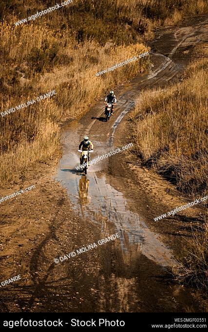 Male bikers with on wet road during enduro motorcycle racing