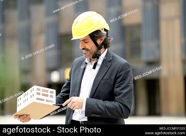 Male architect looking at architectural model