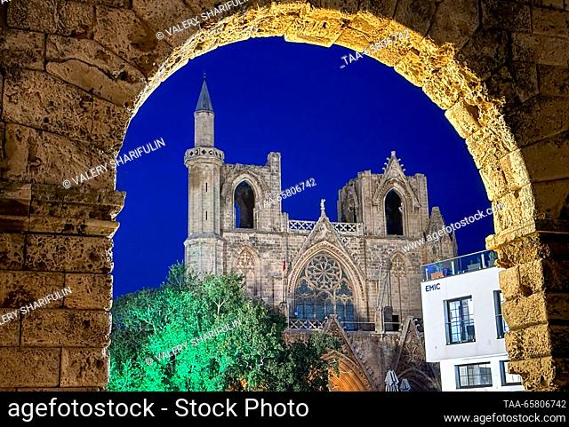 CYPRUS, FAMAGUSTA - DECEMBER 15, 2023: A distant view of the Lala Mustafa Pasha Mosque (the Cathedral of Saint Nicholas) at dusk
