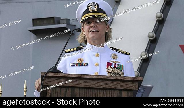 Captain Amy Bauernschmidt, incoming commanding officer of the aircraft carrier USS Abraham Lincoln (CVN 72), reads her orders during a change of command...