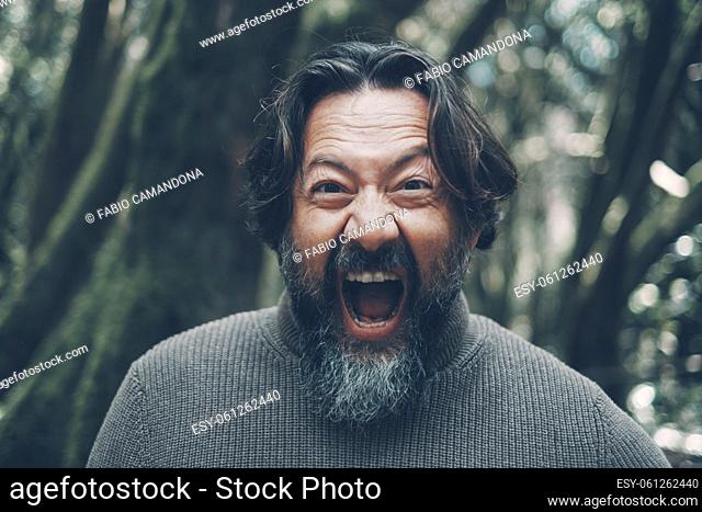 Mad mature man shouting crazy at the camera. Stressed people portrait concept life. Bearded young senior man shout with craziness and open mouth