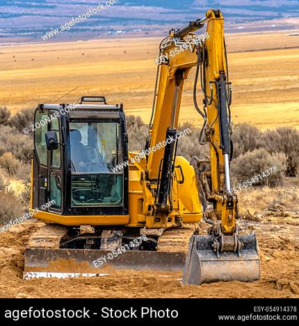 Heavy duty construction machinery in Utah Valley. Heavy duty construction machinery on a development site in Utah. The vast Utah Valley can be seen behind the...