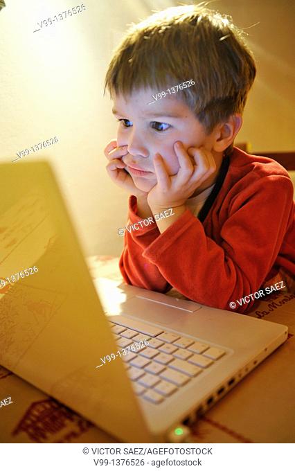 young boy who watches a movie on the computer