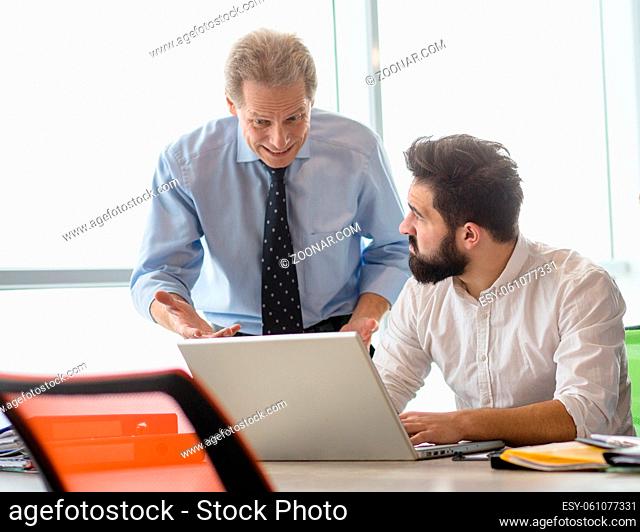 Mobbing, stress, work, scandal concepts. Angry boss man explaining his worker new business strategy while he is working on laptop computer