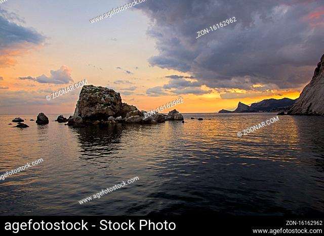 Sunset on the Black Sea coast. View from the embankment of Sudak in the direction of Novyy Svet. Crimea, September