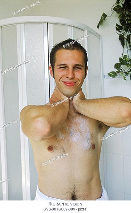 Young man applying moisturizer on his neck