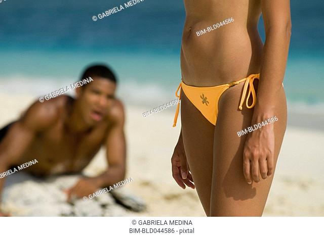 Hispanic man looking at woman on beach