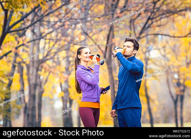 Sport couple drinking refreshing water having break from running
