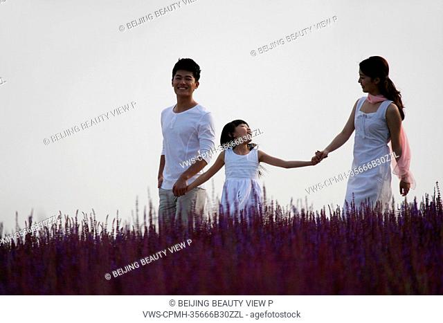 Oriental family standing in lavender garden
