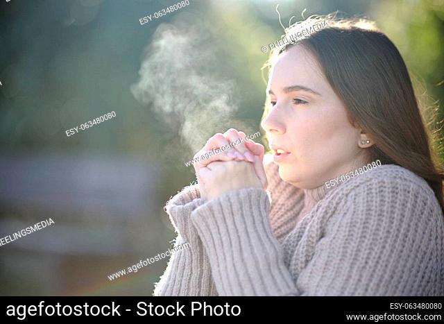 Woman breathing and getting cold in winter in a park