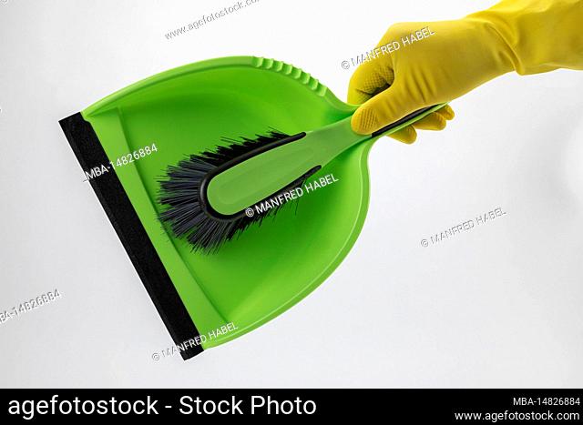 Hand holding green sweeping set, protective glove yellow, (M), white background