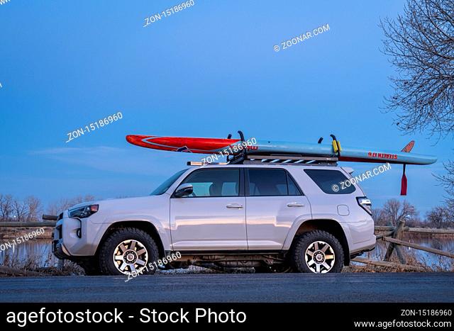 Fort Collins, CO, USA - March 15, 2020: After paddling - Toyota 4Runner SUV (2016 trail model) with a racing stand up paddleboard (Stealth Mistral) at dusk on...