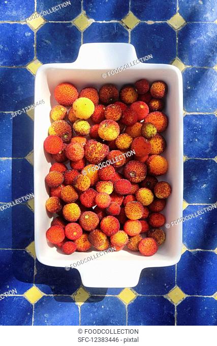 Fruits from the strawberry tree in a white dish