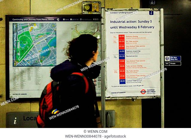 Commuters pass by a London underground tube strike poster displayed at Manor House. Industrial action is due to begin on Sunday 5th February and continue until...