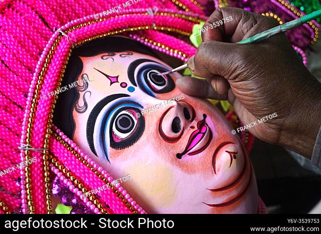 A craftsman is painting a Purulia Chhau dance mask ( West Bengal, India)