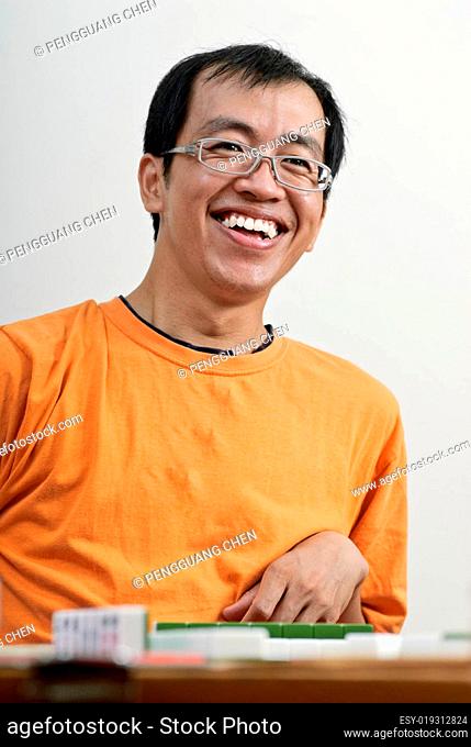 Happy smiling Asian man play Mahjong
