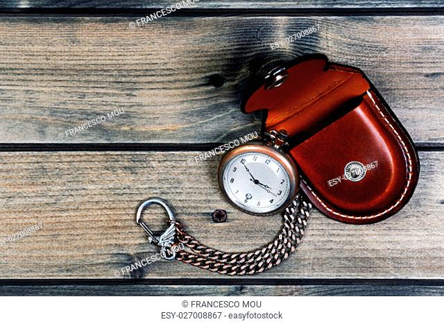 Picture of a antique pocket watch with case of old wood background