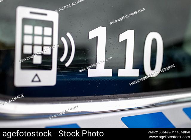 04 August 2021, Bavaria, Nuremberg: SYMBOL PHOTO - The police emergency number 110 is written on the window of a police vehicle
