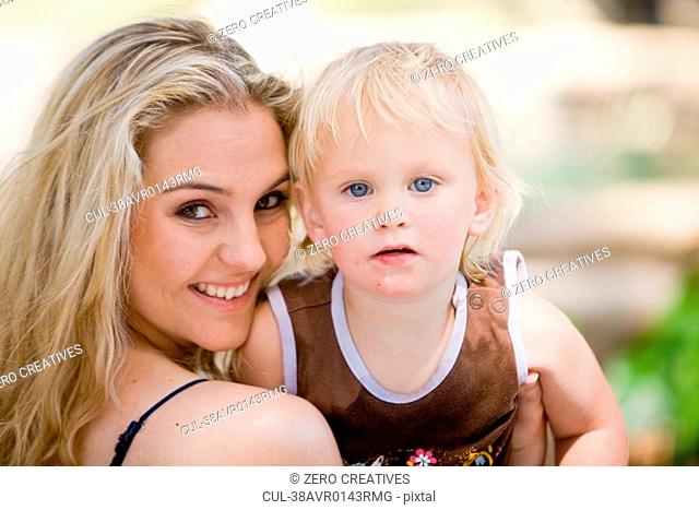 Mother holding daughter outdoors
