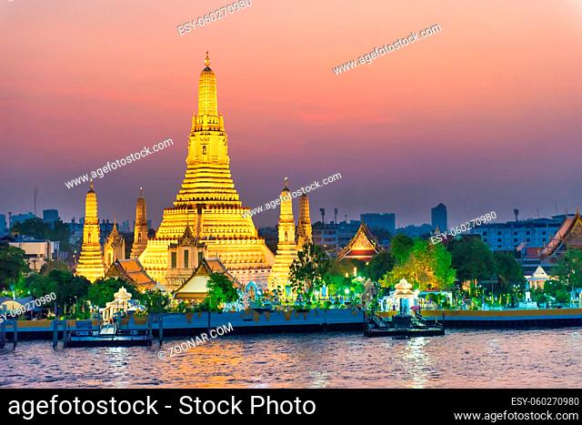 Night Illuminated Temple of Dawn or Wat Arun and Thonburi west bank of Chao Phraya River at sunset. Bangkok, Thailand