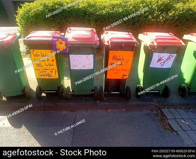 HANDOUT - 23 March 2020, Hamburg: Self-painted posters and thanksgiving stick to garbage cans. Despite the Corona crisis