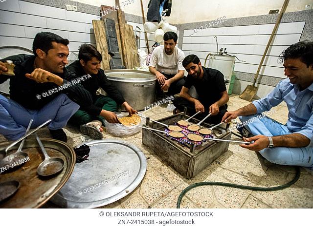 Men cooking beryun, dish contains cutlet made from lamb, cooked in a special small pan over open fire and enfolded in certain type of bread