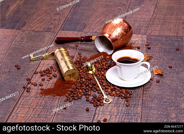 Coffee grinder, pot and grains on wooden table
