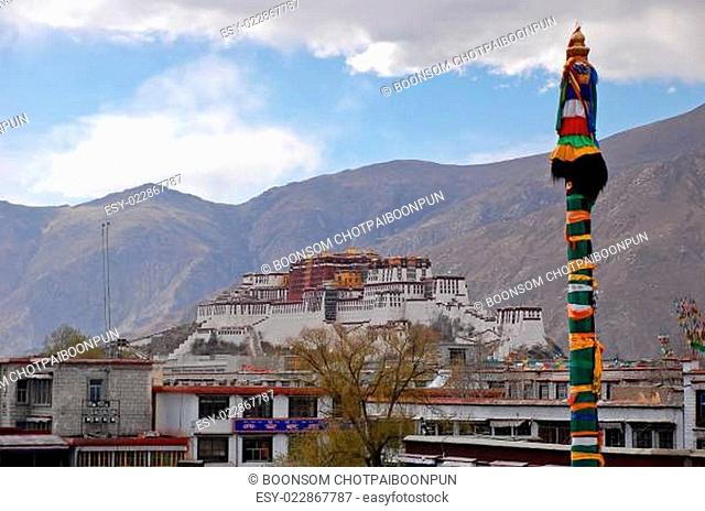 Pole design with silk scarfs in Jokhang temple on the background of Potala palace, Tibet