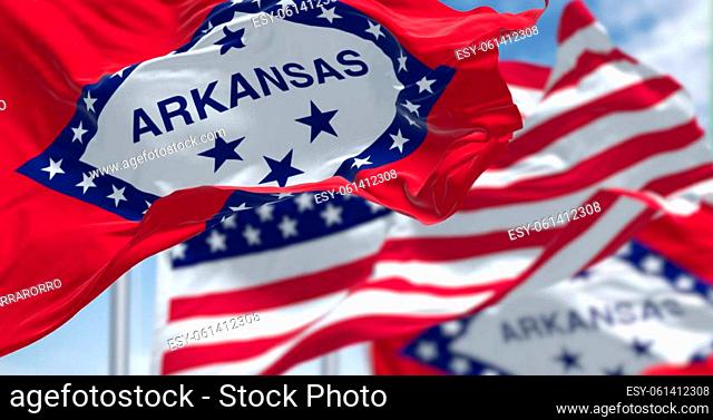 The flags of the Arkansas state and United States waving in the wind. Democracy and independence. US state flag