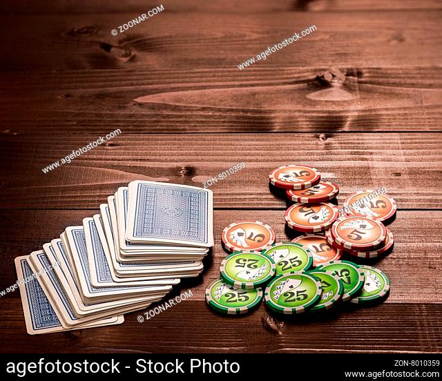 old vintage cards and a gambling chip on a wood table