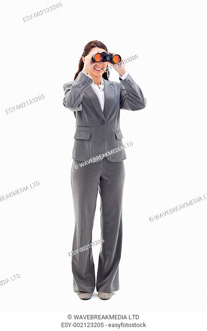 Businesswoman smiling and looking through binoculars on the left side against white background