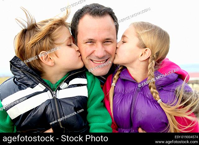 Kids giving a kiss to their daddy