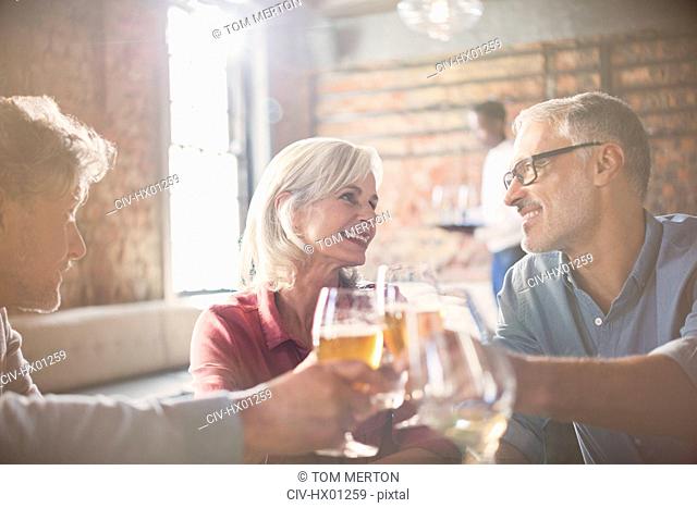 Smiling friends toasting beer and wine glasses in restaurant