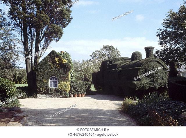 Large topiary train beside garden building covered with ivy