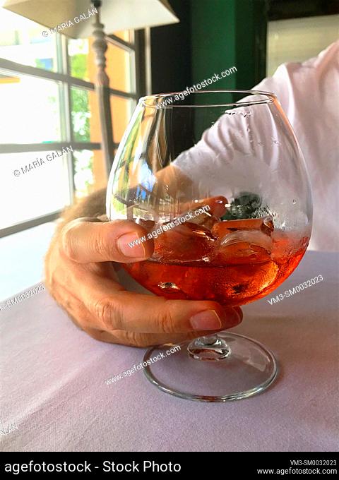 Man's hand holding a glass of liqueur