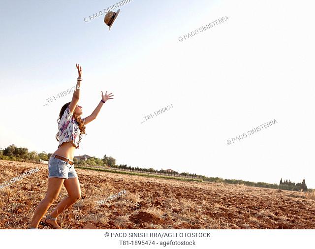 girl throwing a hat into the air