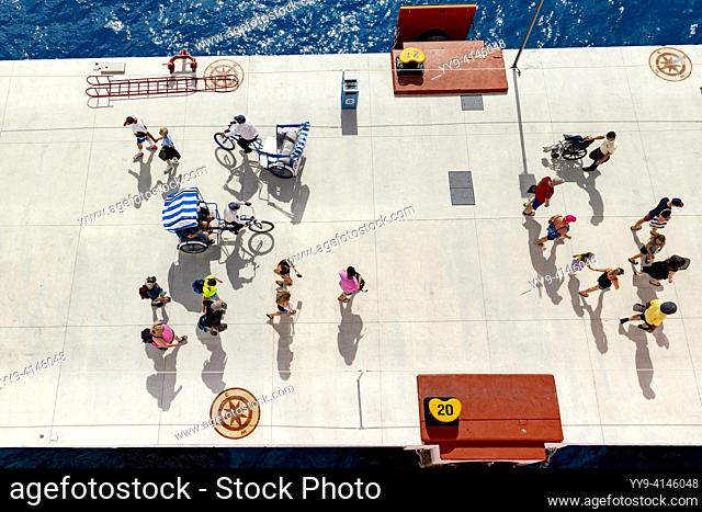 Overhead view of people walking and bicycle taxis at the cruise terminal in Cozumel, Mexico