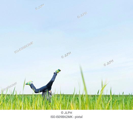 Boy cartwheeling in grass