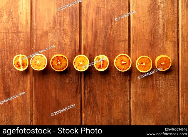 A photo of organic blood oranges, shot from above on a dark rustic background with copy space