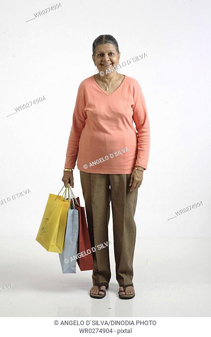 Old lady holding colourful shopping bags in her right hand MR 703A