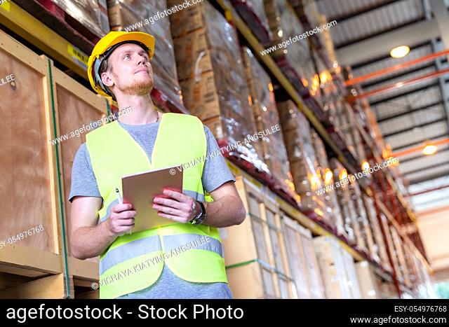 Portrait white caucasian warehouse worker stand with digital tablet for inventory checking in large warehouse distribution center