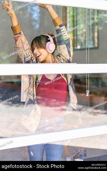 Female painter dancing near window in studio
