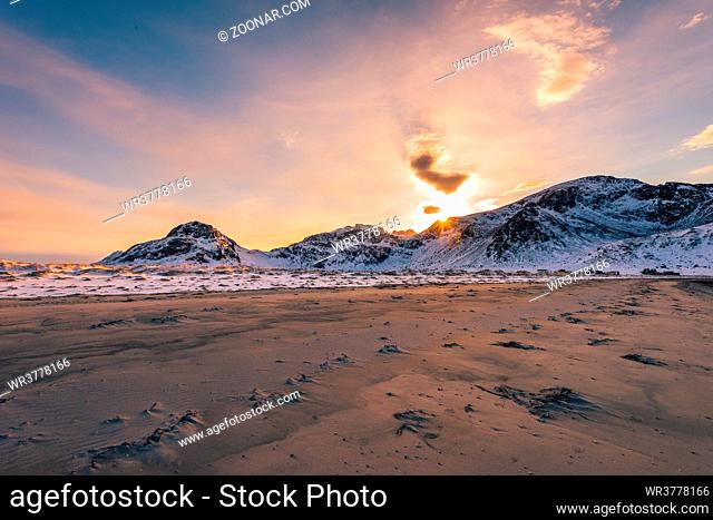Scenic view over the sand beach near the village Fredvang while hiking in Ytresand on the Lofoten islands archipelago in Norway in golden sunset light on clear...